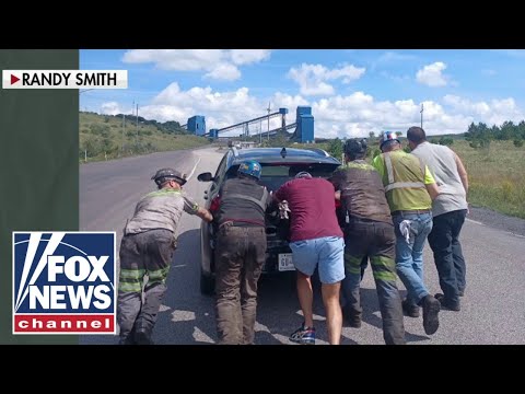 You are currently viewing Coal miners shown pushing broken down electric vehicle